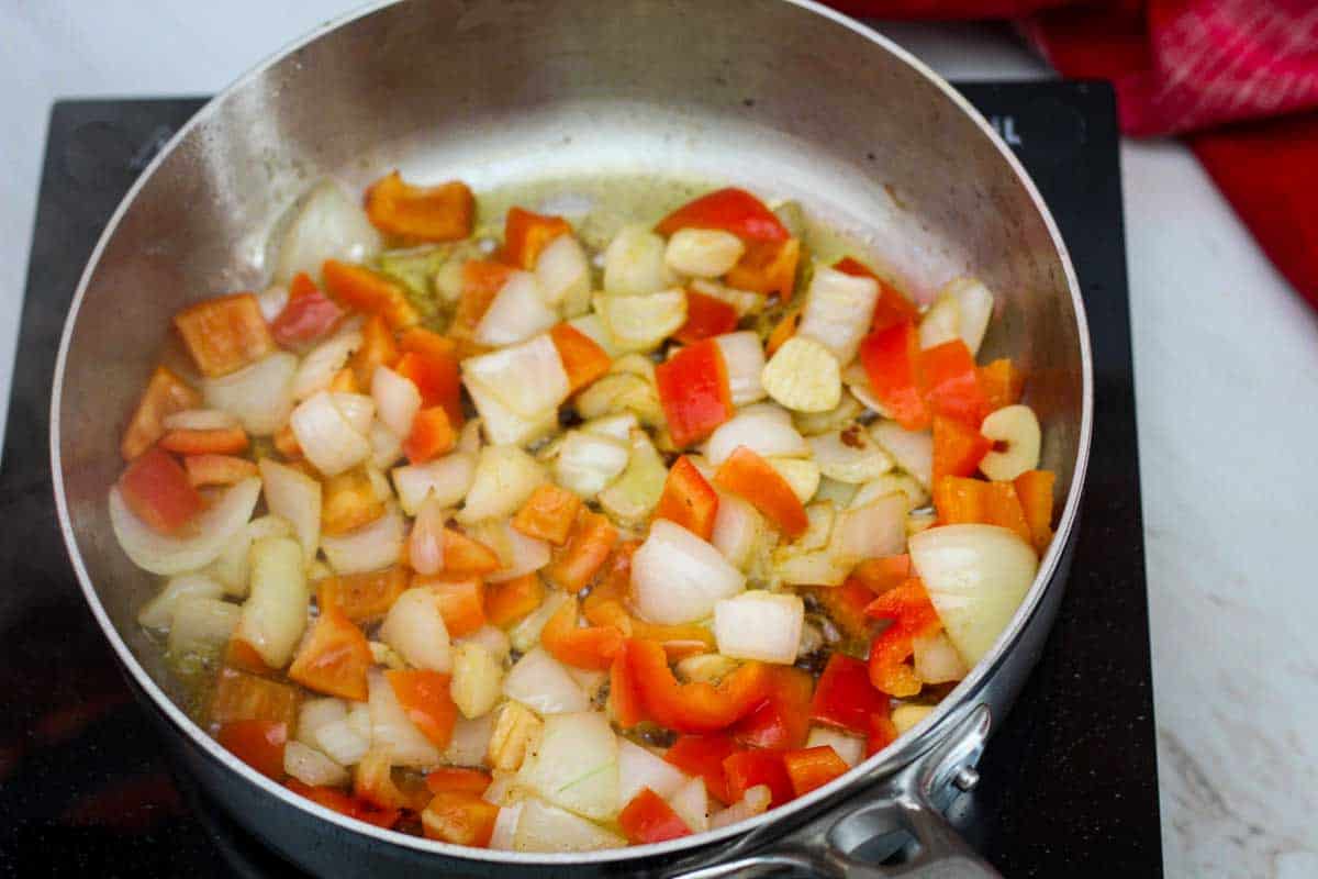 Sauteing onions, peppers in a large skillet.