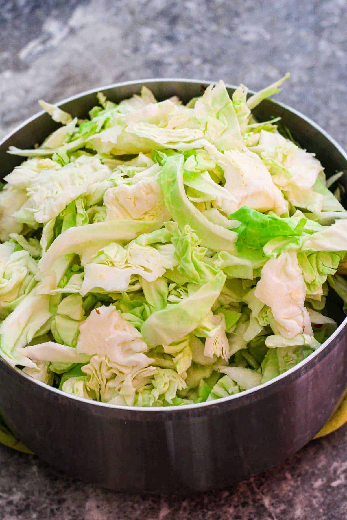 Adding cabbage to stew pot.