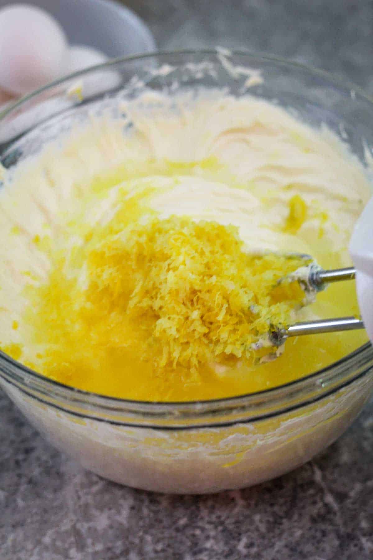 Adding lemon zest and lemon juice to whipped cream cheese, sugar and vanilla mix.