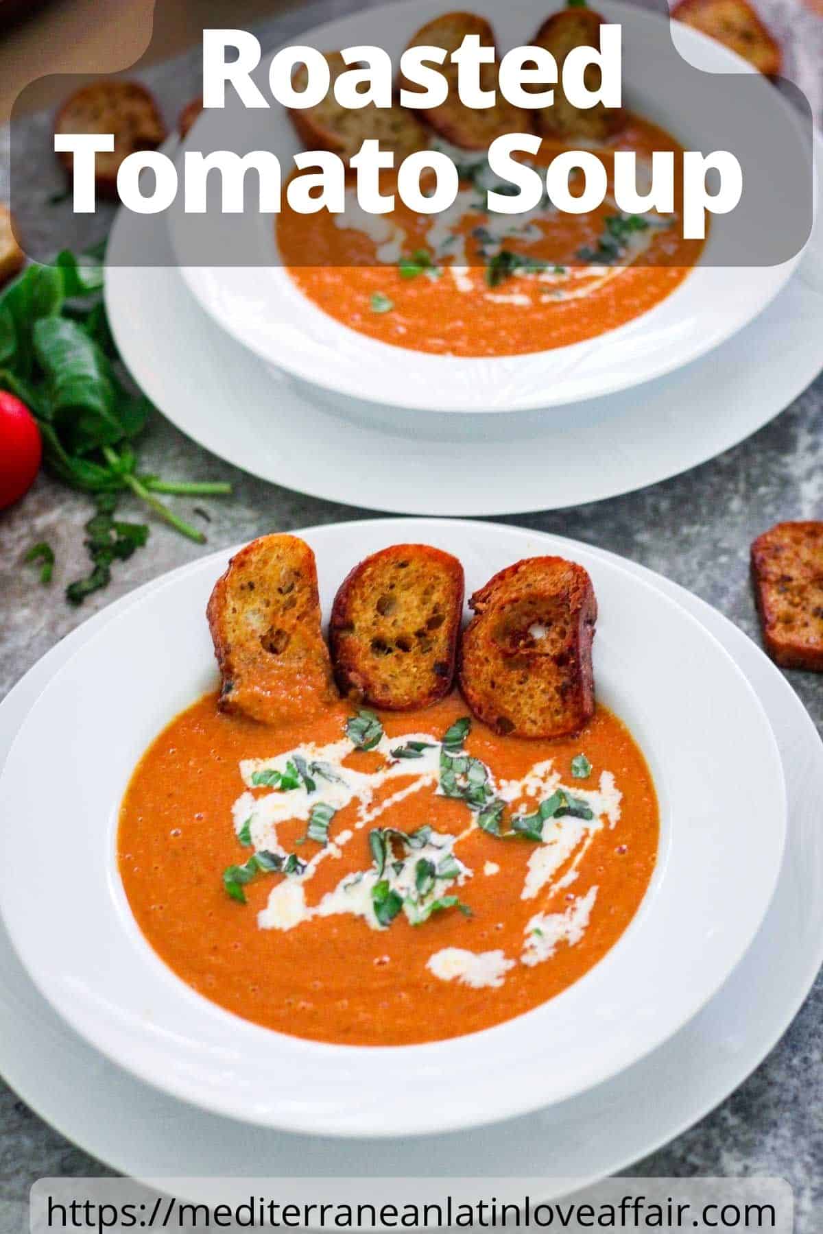 An image prepared for Pinterest. It shows several servings of tomato soup, garnished with basil, cream and croutons. There's a title bar on top of the picture and a website link at the bottom. 