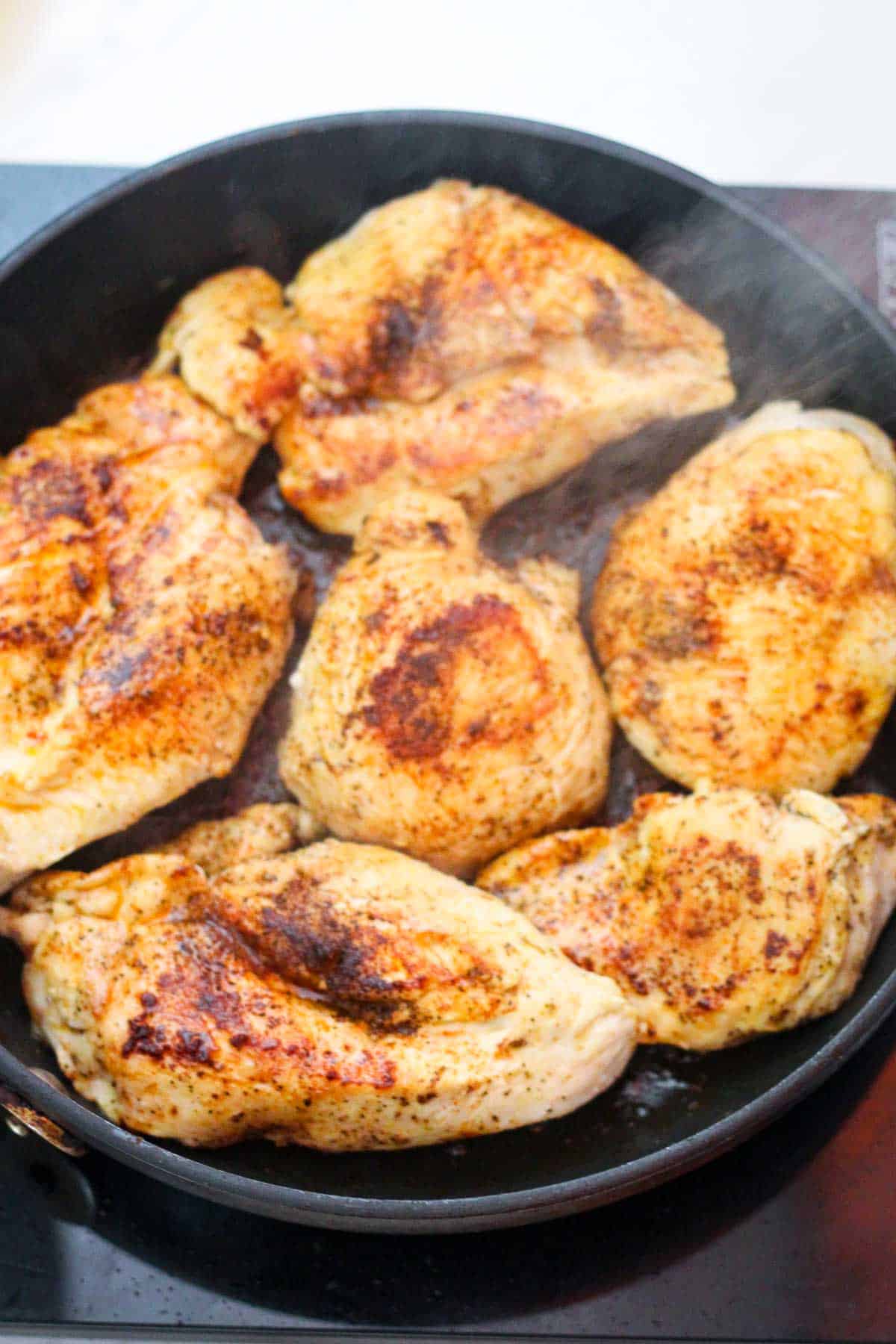 Searing chicken on the other side in the skillet.