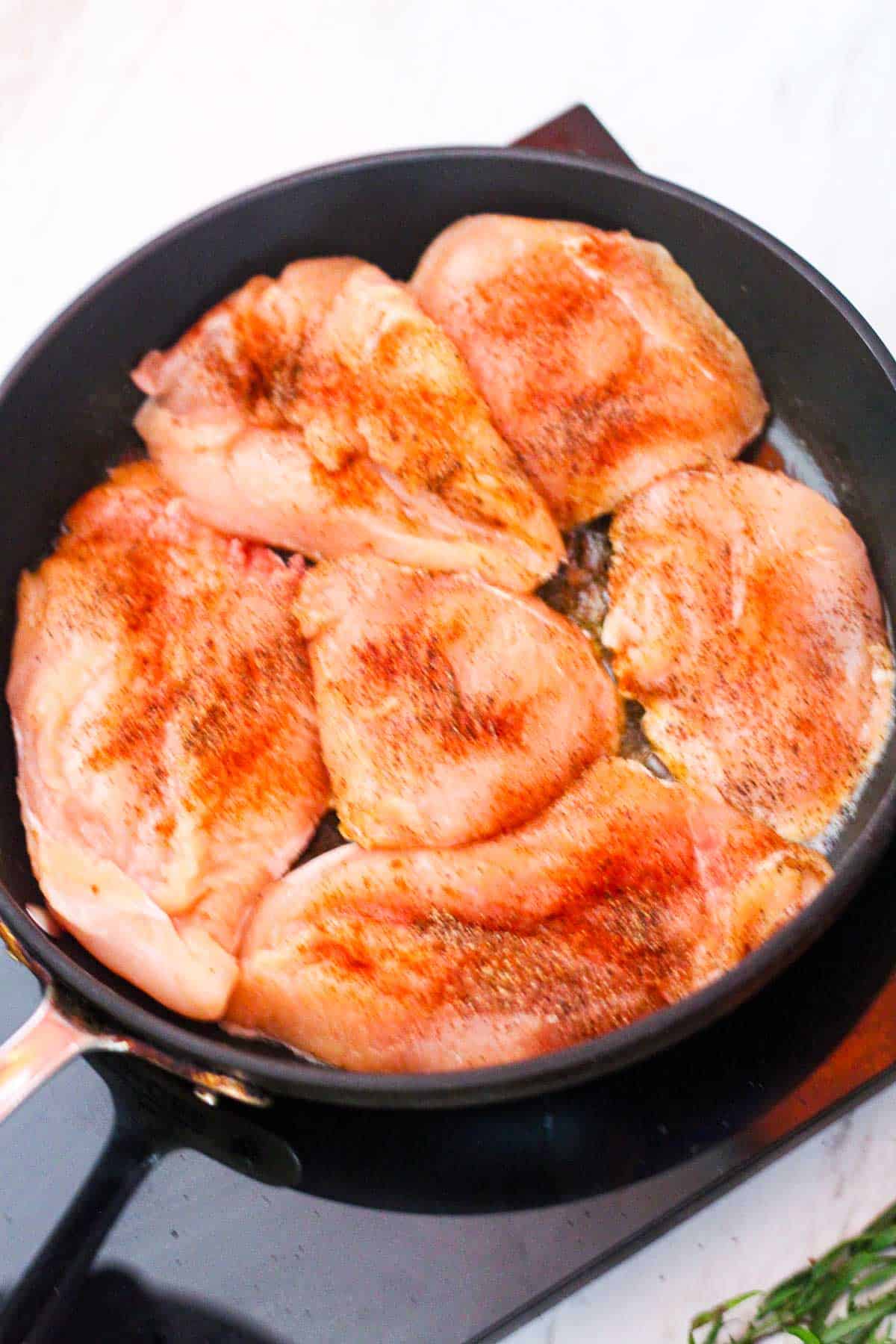 Searing chicken in butter on the skillet.