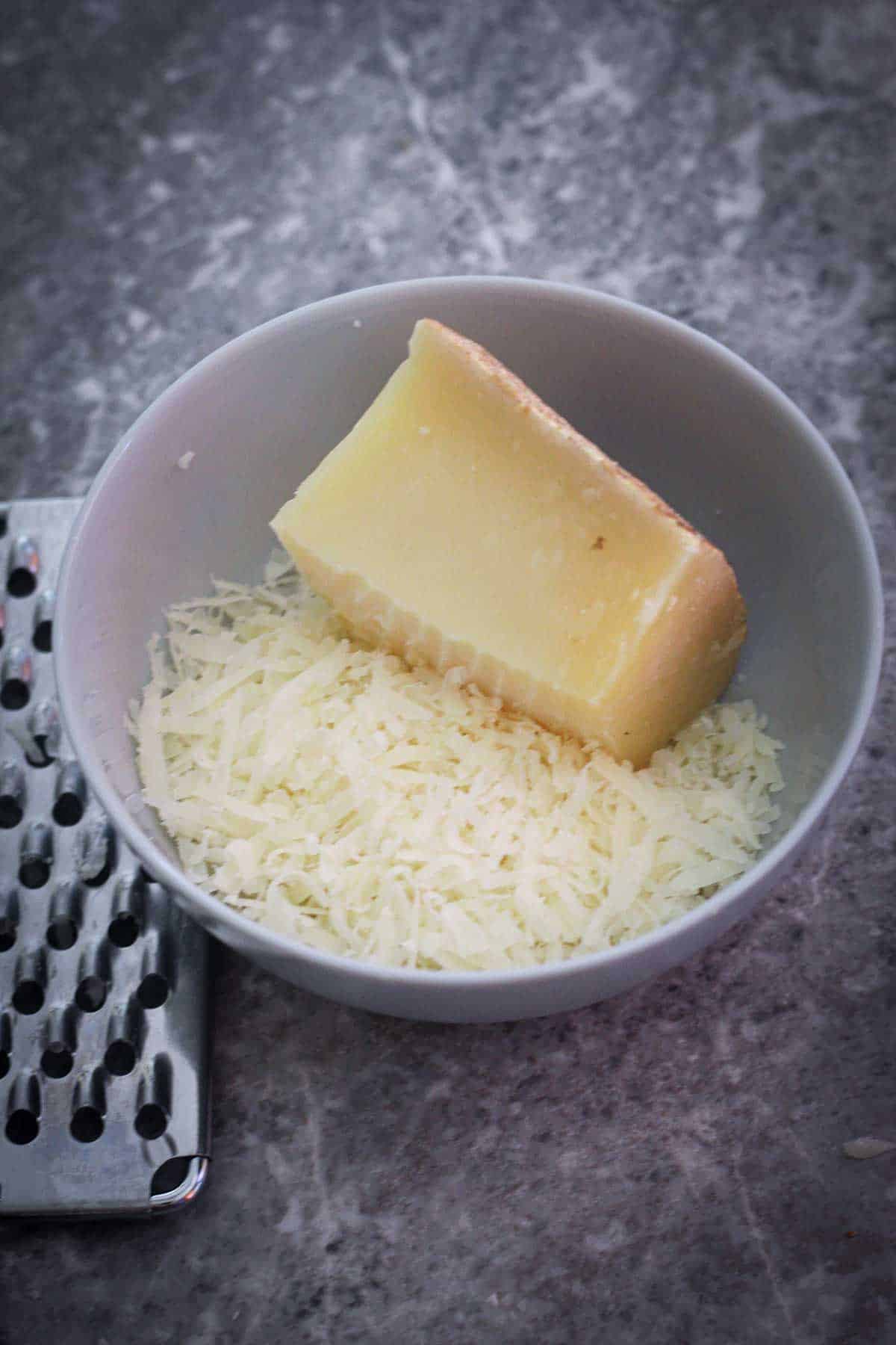 Grating pecorino cheese in a bowl.