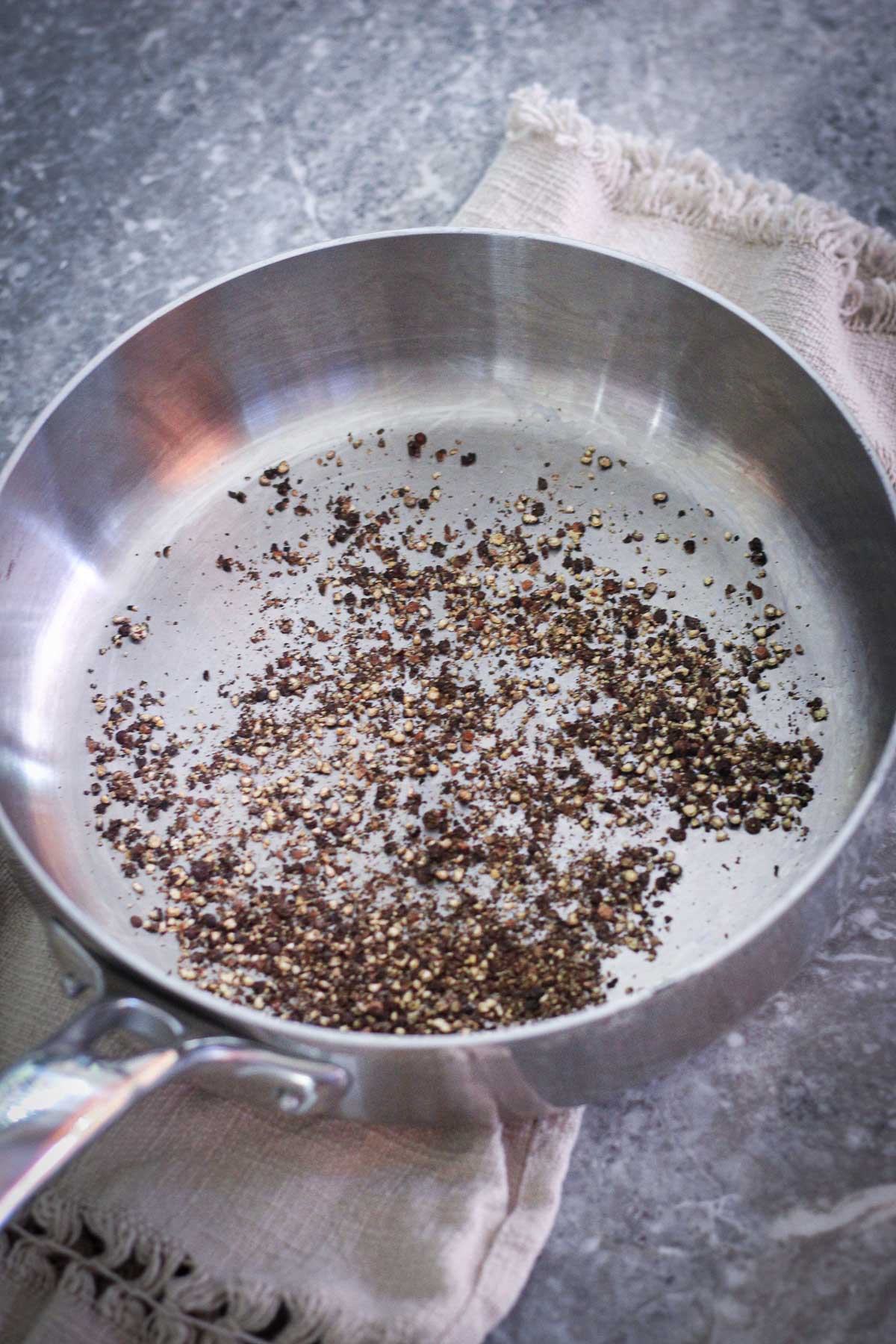 Toasting ground peppercorn in a pan.