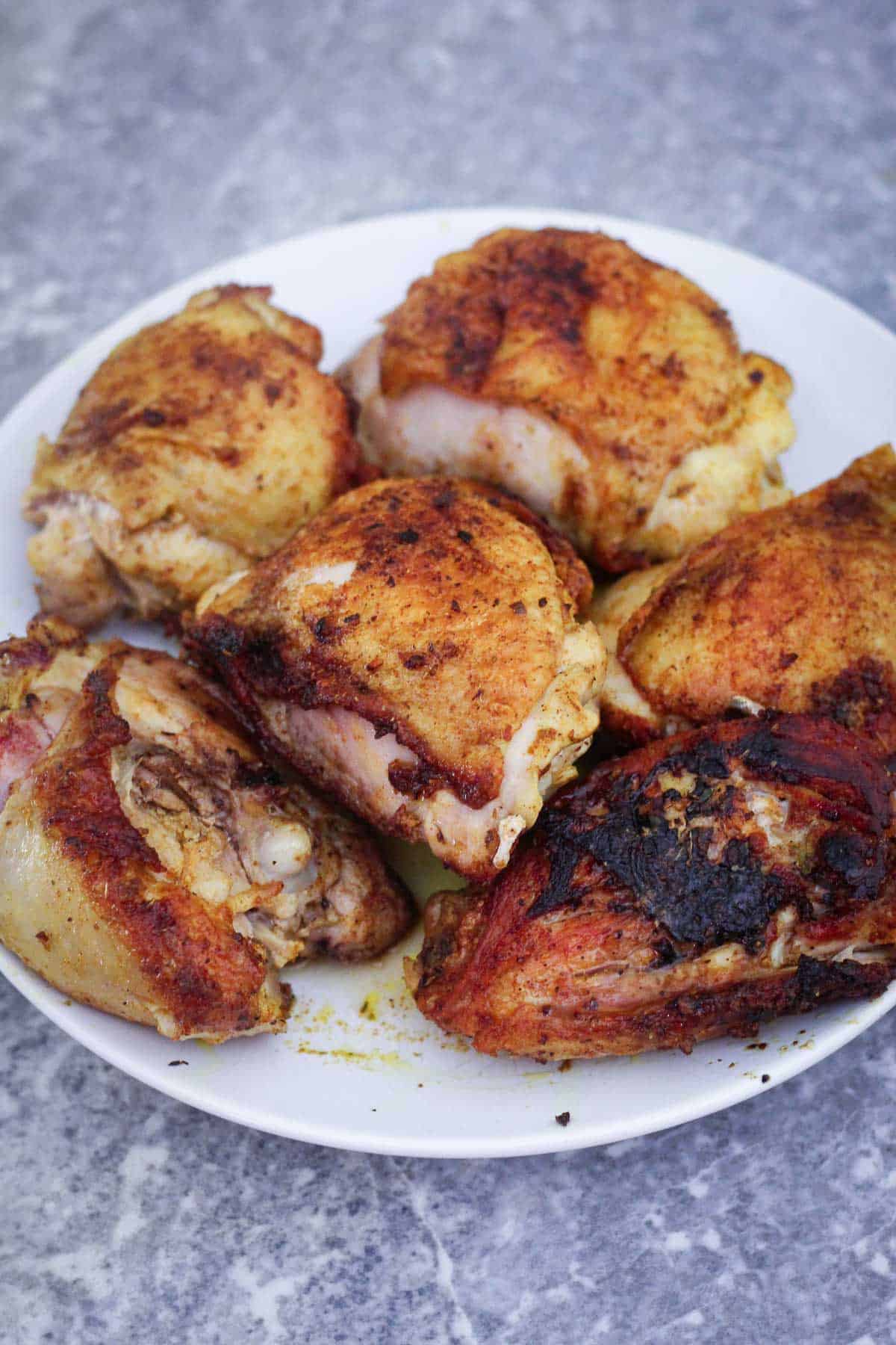 Browned chicken thighs on a platter.
