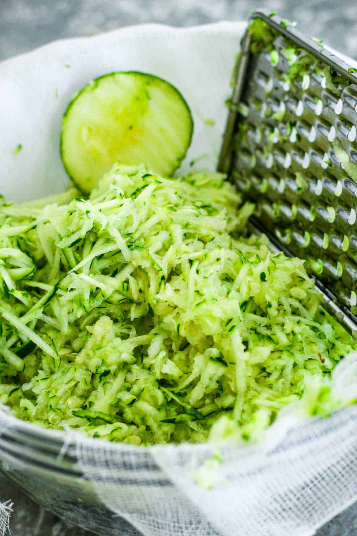 Grating zucchini on a bowl.