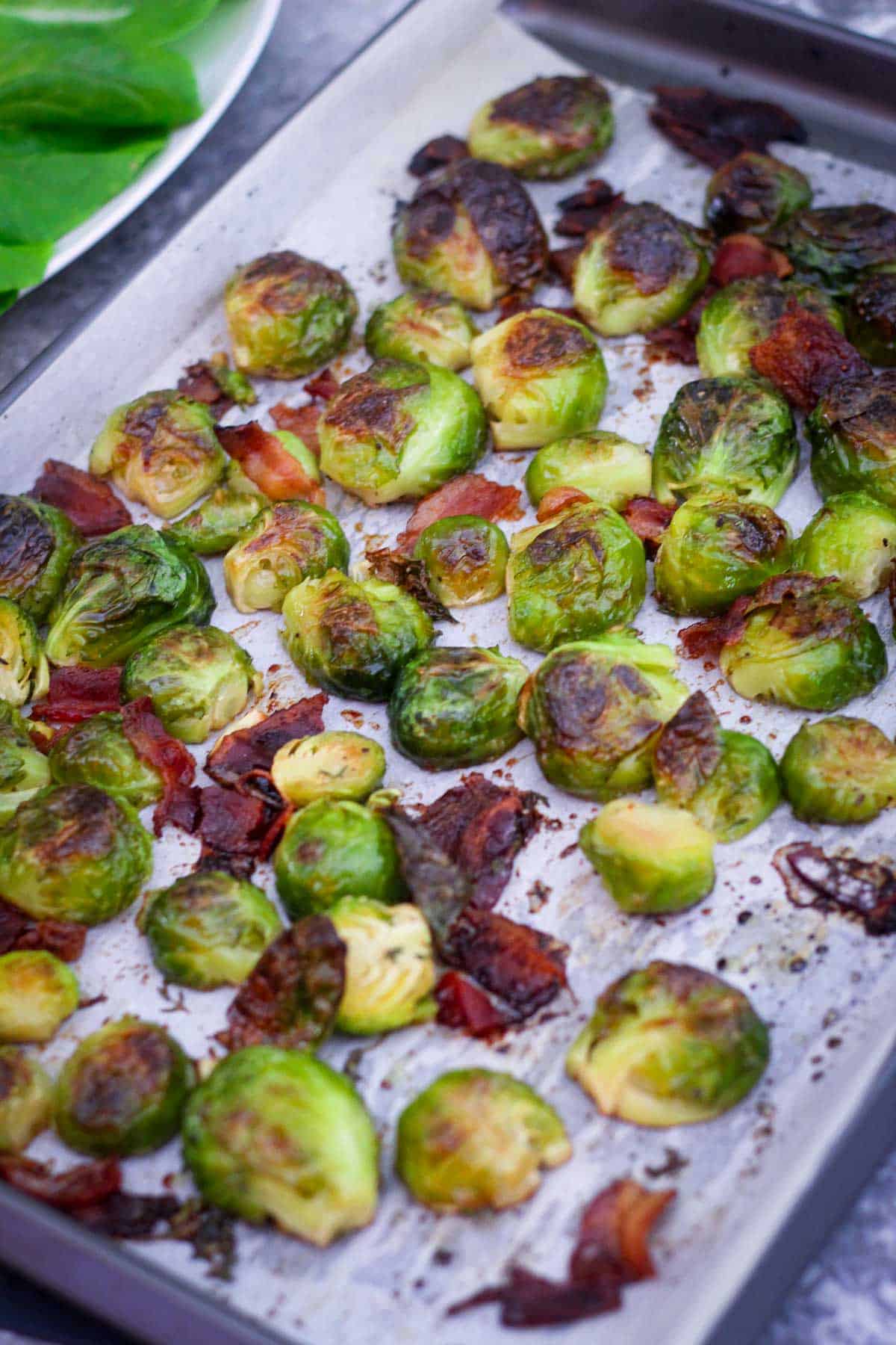 Roasted Brussel sprouts with bacon just out of the oven on the baking sheet. 