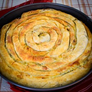 Spiral phyllo pie shown baked in a round baking dish.