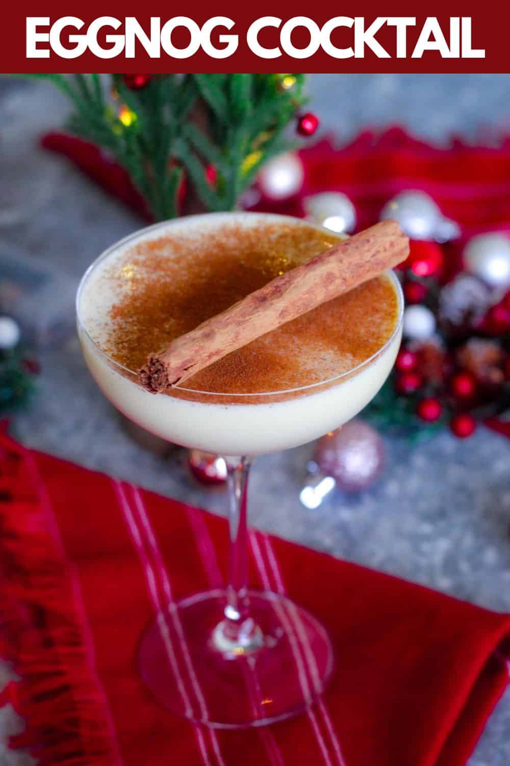 An image prepared for Pinterest, it shows an eggnog cocktail in a coupe glass in a festive. setting. There's a title bar over the image. 