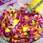 A salad glass bowl showing a red cabbage salad with mango and other ingredients.
