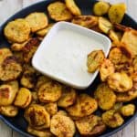 A round dish with crispy harissa potatoes and a dip in the middle.