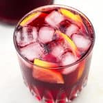A glass with Spanish tinto de verano drink, filled with ice and lemon slices too, seen from above.