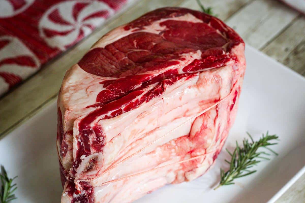 Side View of prime rib cut, raw on a platter. 