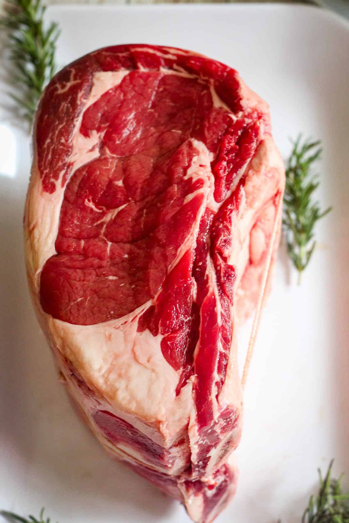 Raw Prime Rib shown on a platter from above. 