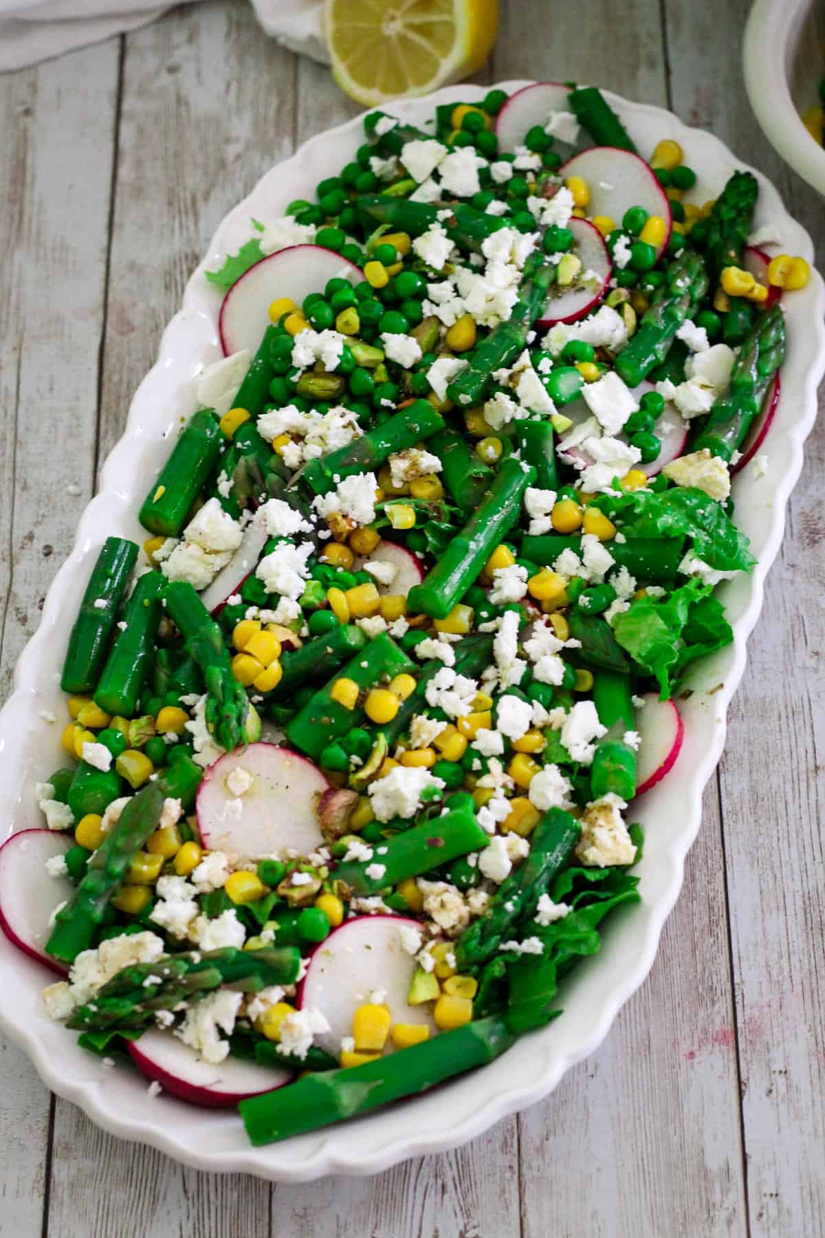 Spring asparagus salad will be shown on a platter, garnished with feta cheese. 