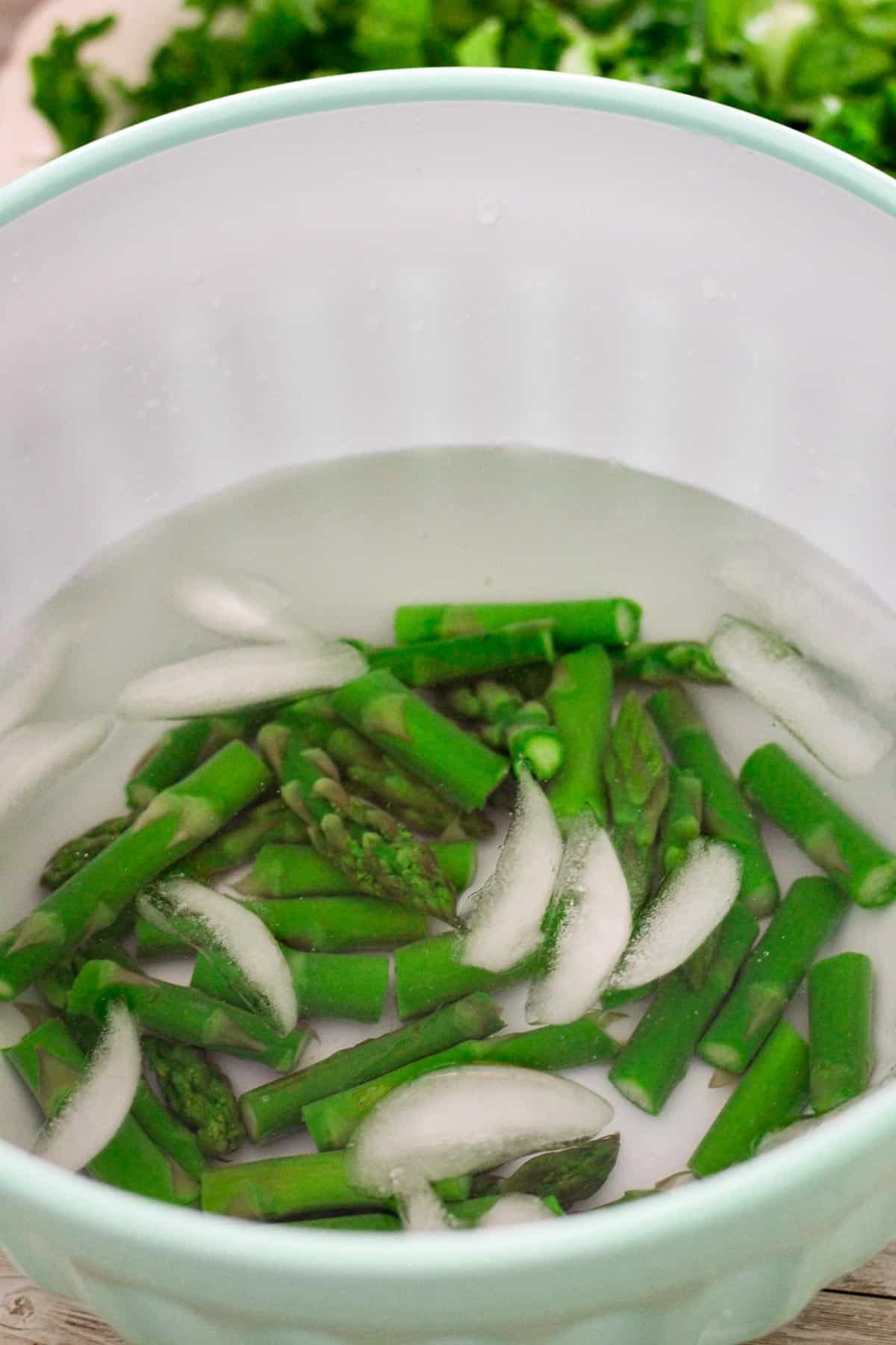 Blanching asparagus in ice water after boiling. 