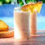 A tropical smoothie poolside. In the picture you see you two cups, garnished with pineapple wedges.