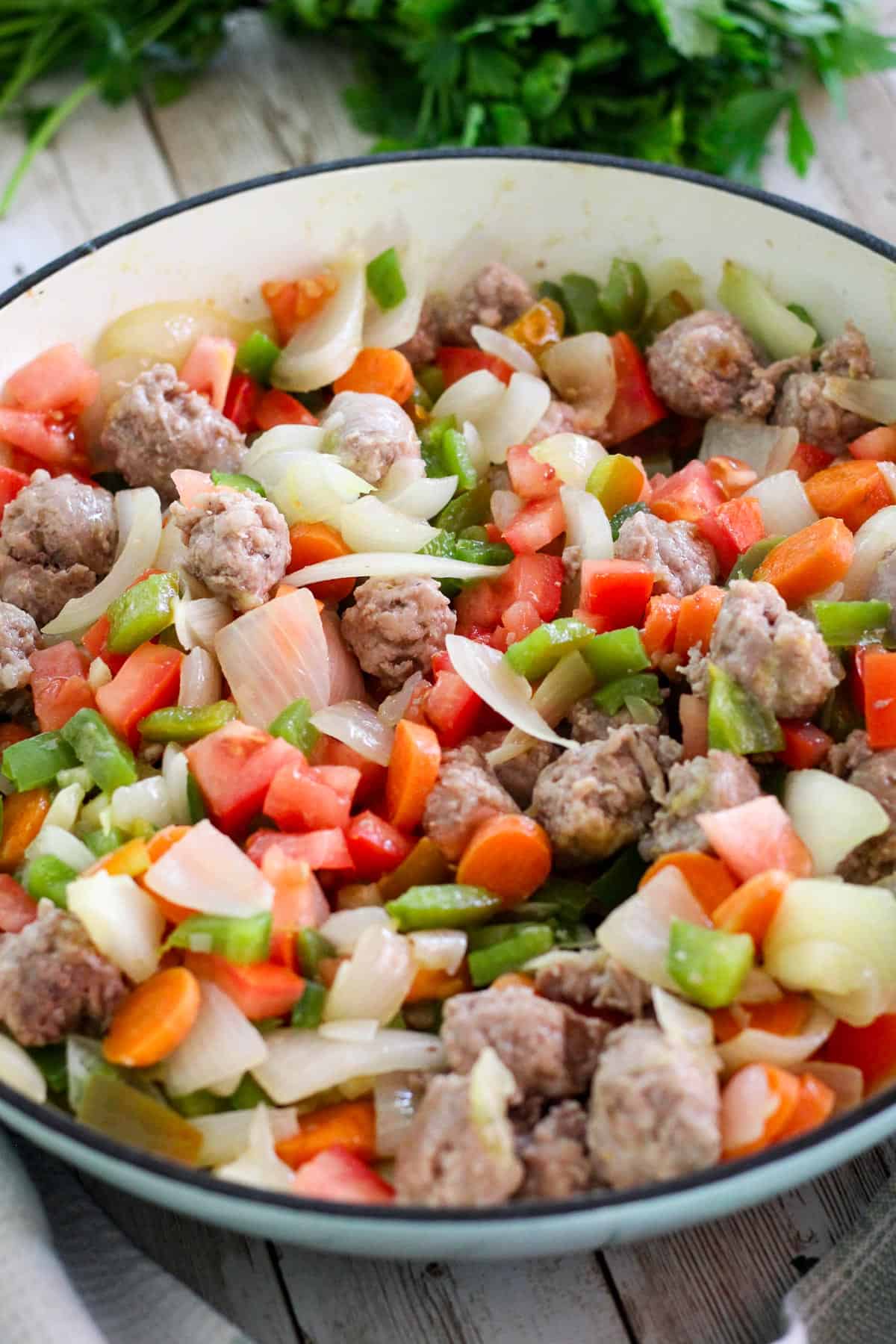 Braiser with sauteed veggies with added sausage in.