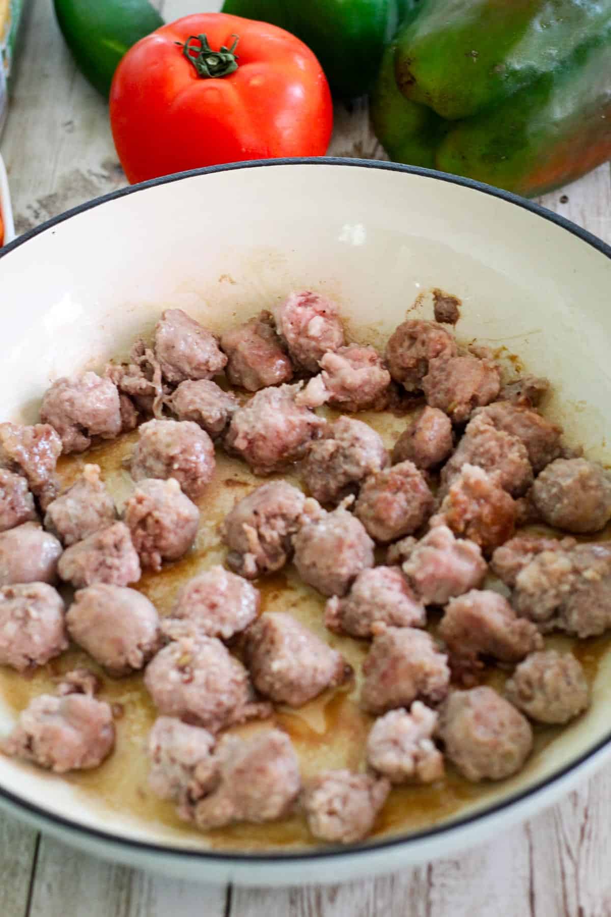 Browning sausage in a braiser. 