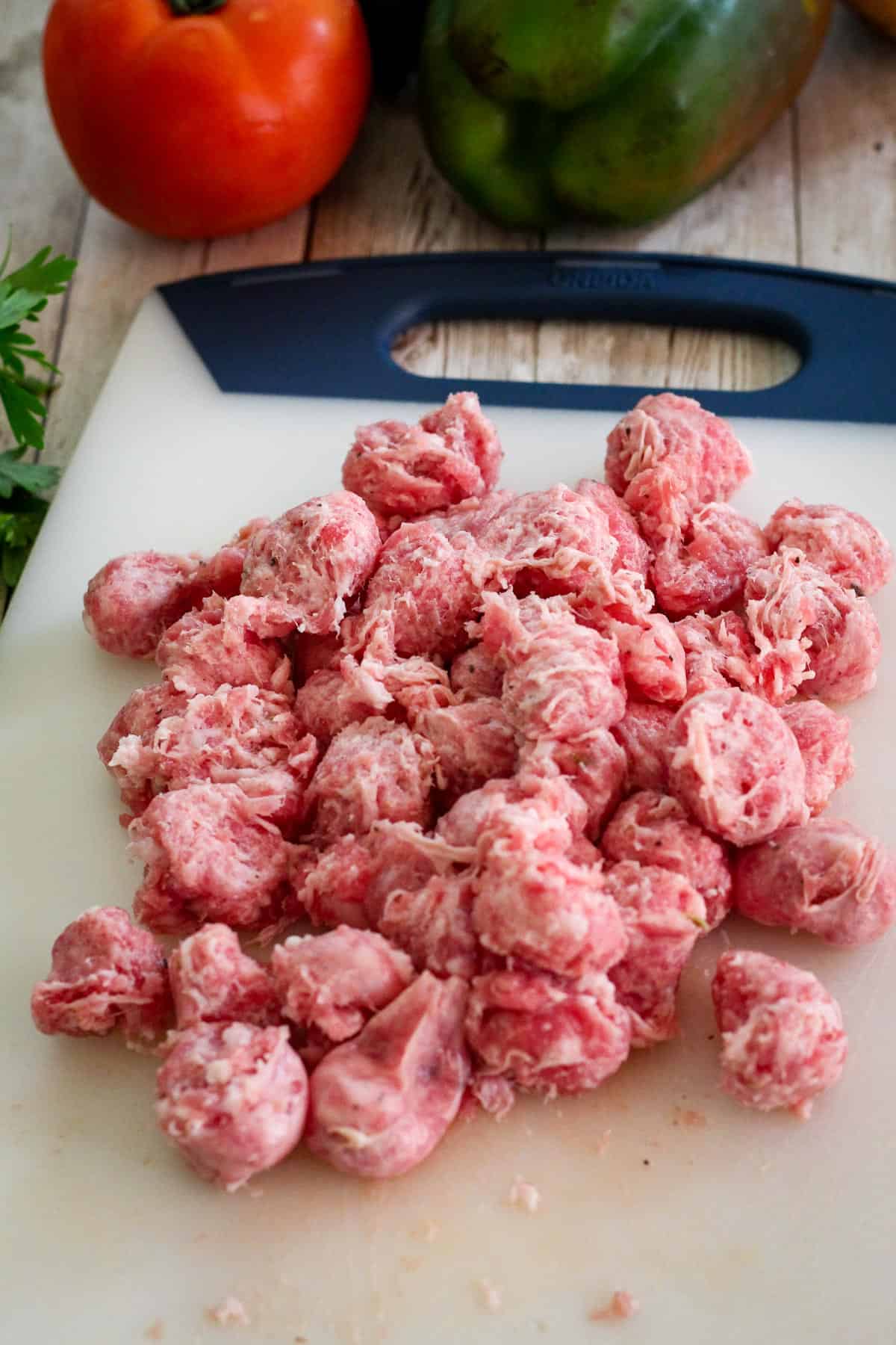 Raw sausage, cut, in a cutting board.