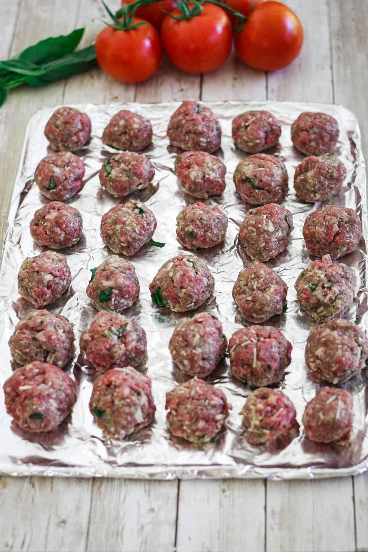 Meatballs in a baking sheet, ready to bake. 