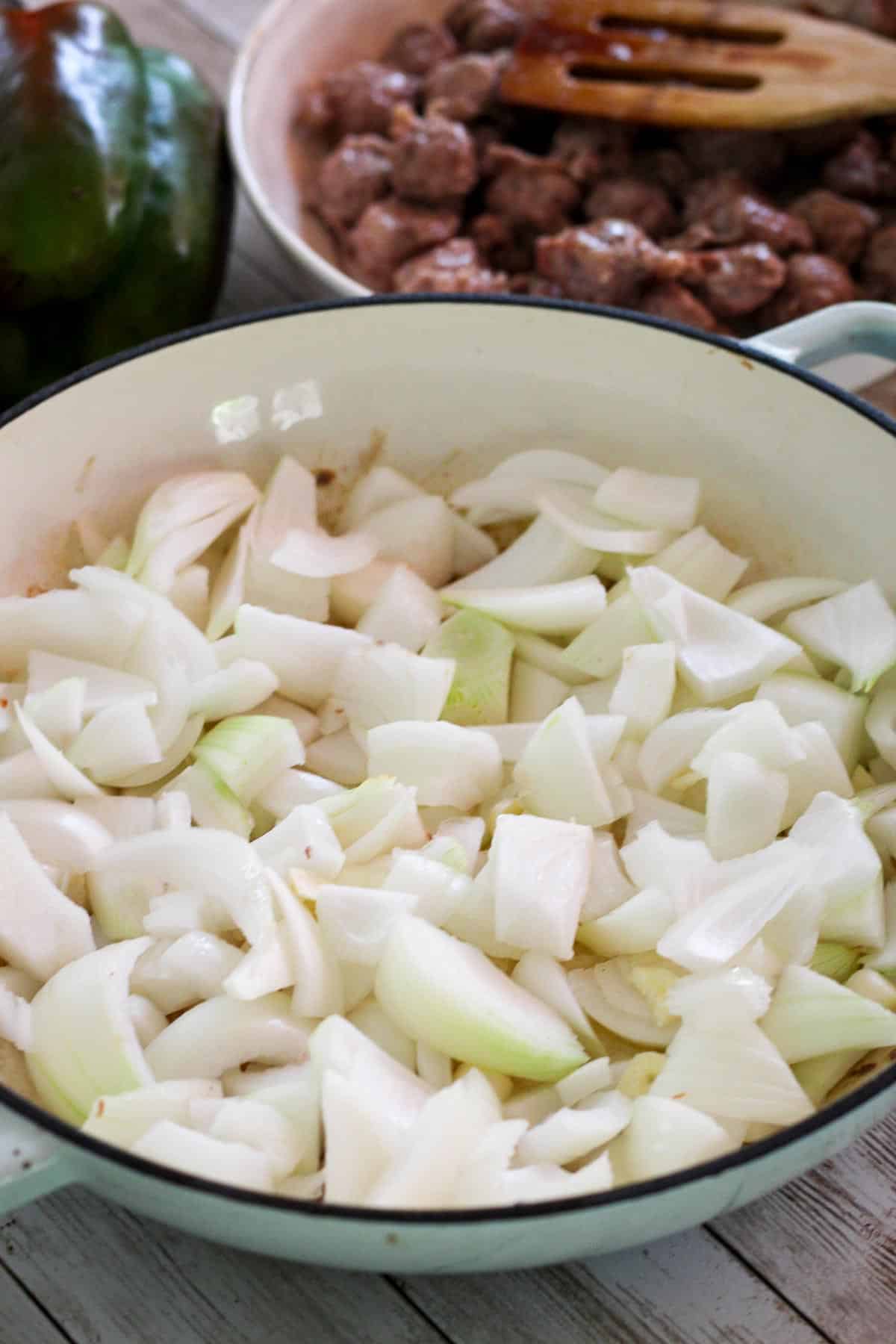 Sauteing onions in a braiser, onions are roughly chopped. 