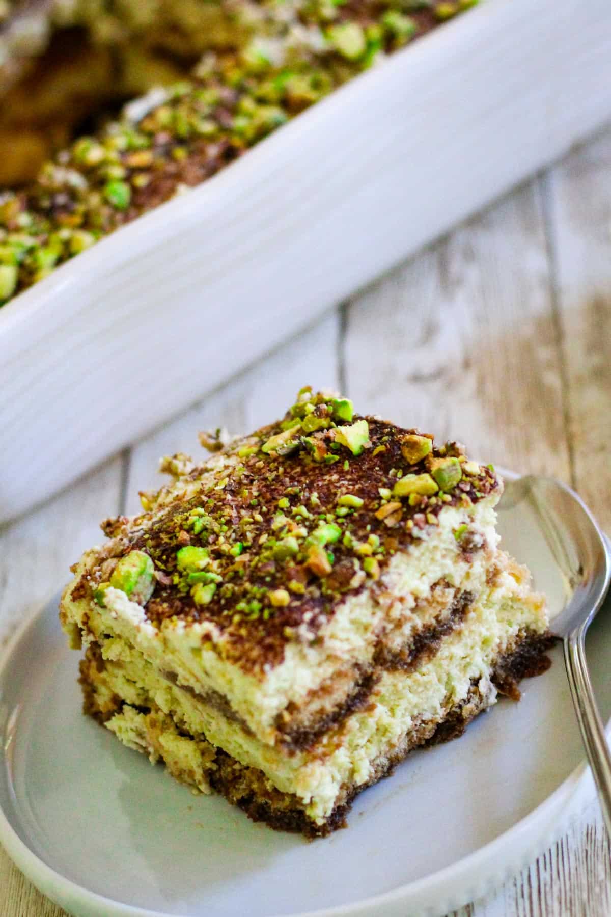 Slice of tiramisu covered with pistachios. 