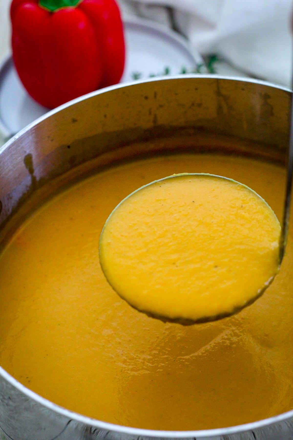 A ladle serving butternut squash soup.