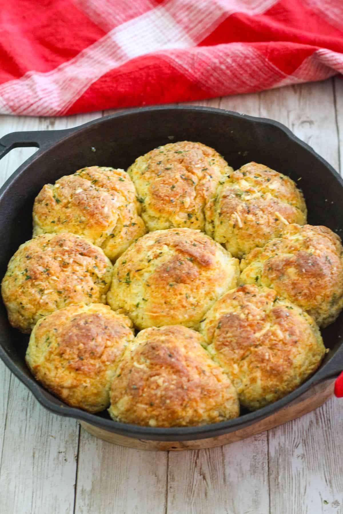 Buttermilk, three cheese biscuits baked in a cast iron skillet, you see 9 of them in the skillet.