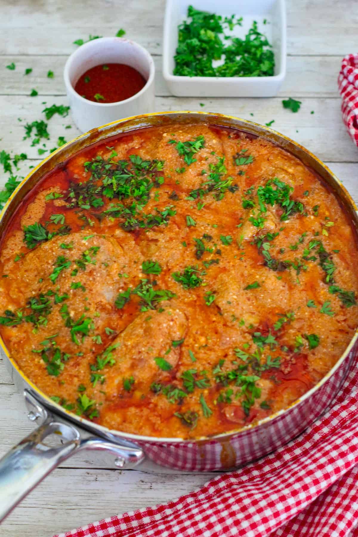 A pot of chicken paprikash dish, garnished with fresh parsley. 