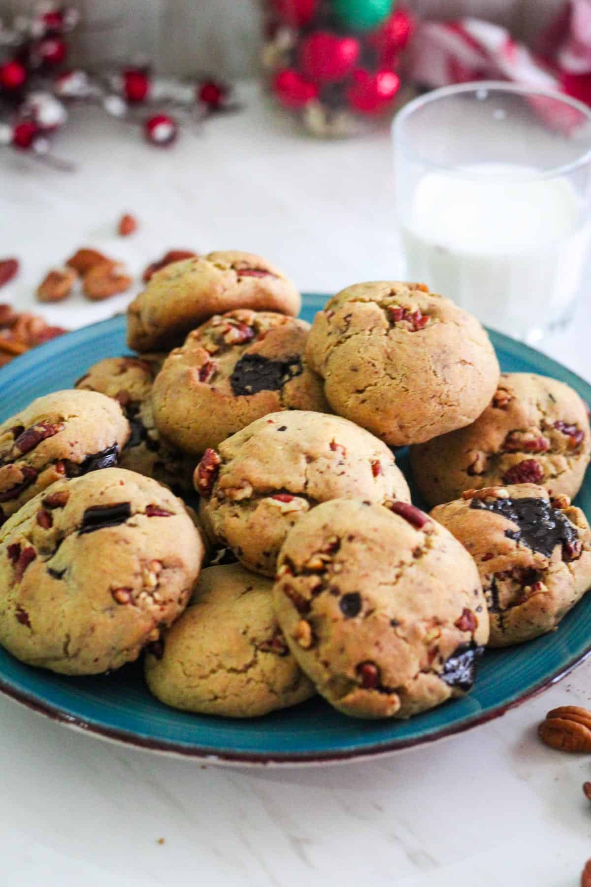 A plate with butter pecan cookies, shown next to a cup of milk.