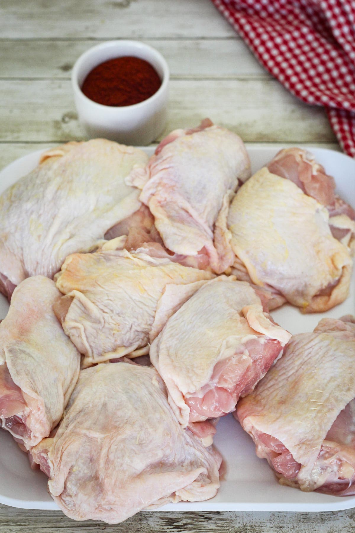 Raw chicken thighs on a plate. 