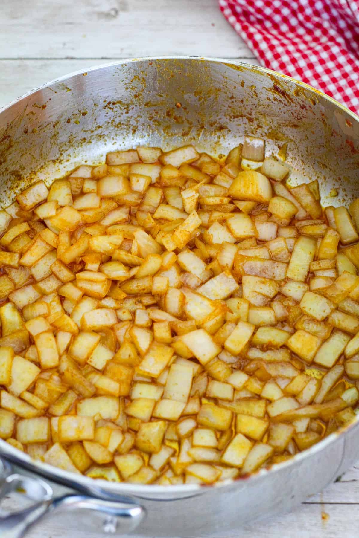 Sauteing onions in the skillet where chicken was previously browned, so onions become reddish from scraping the skillet. 