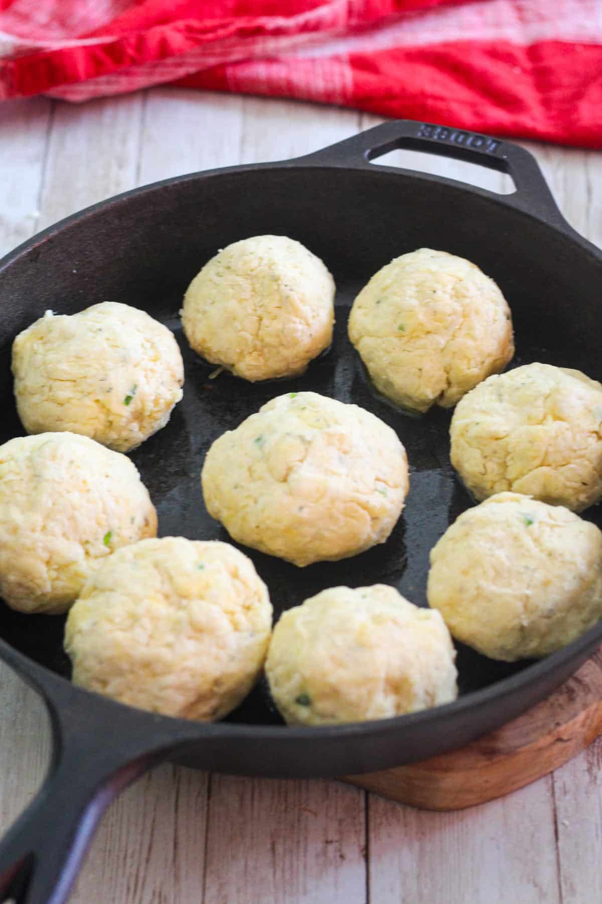 Dough shaped in ball shape and placed on the cast iron skillet, ready to bake.