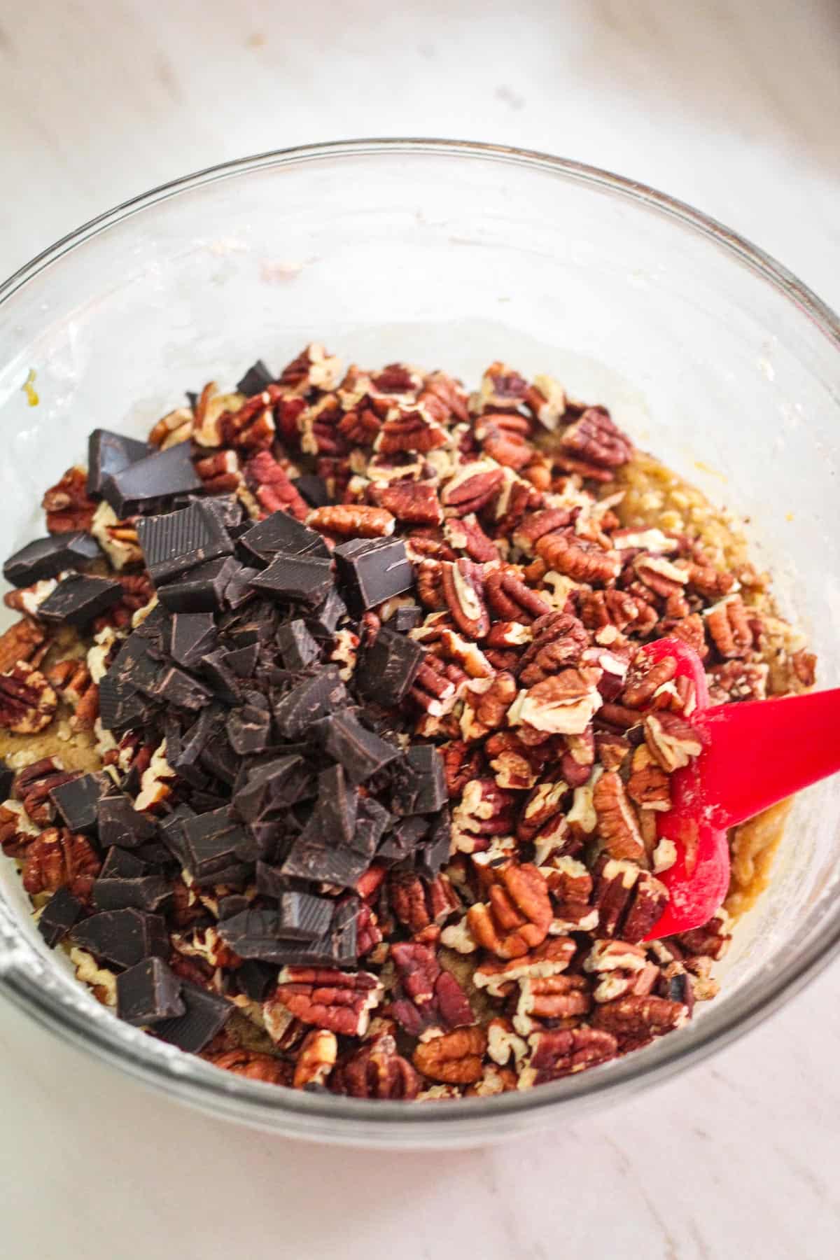 Chopped pecans and dark chocolate have been added over the dough.