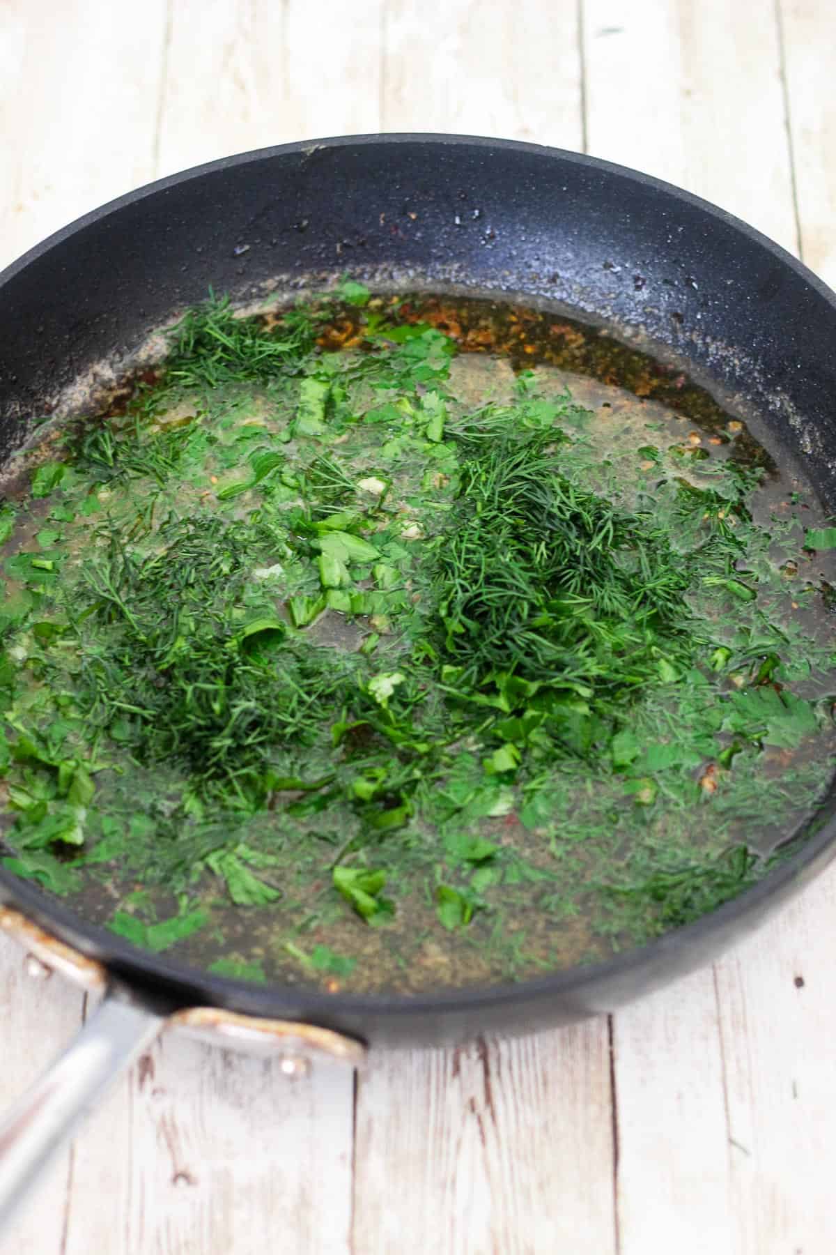 Pan is now shown with the sauce when parsley and dill are added to it.
